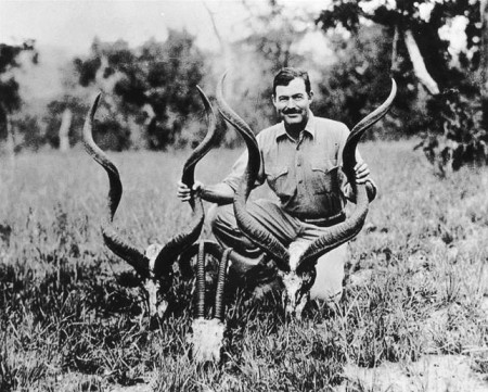 Hemingway with kudu and oryx heads, 1934. Public domain.